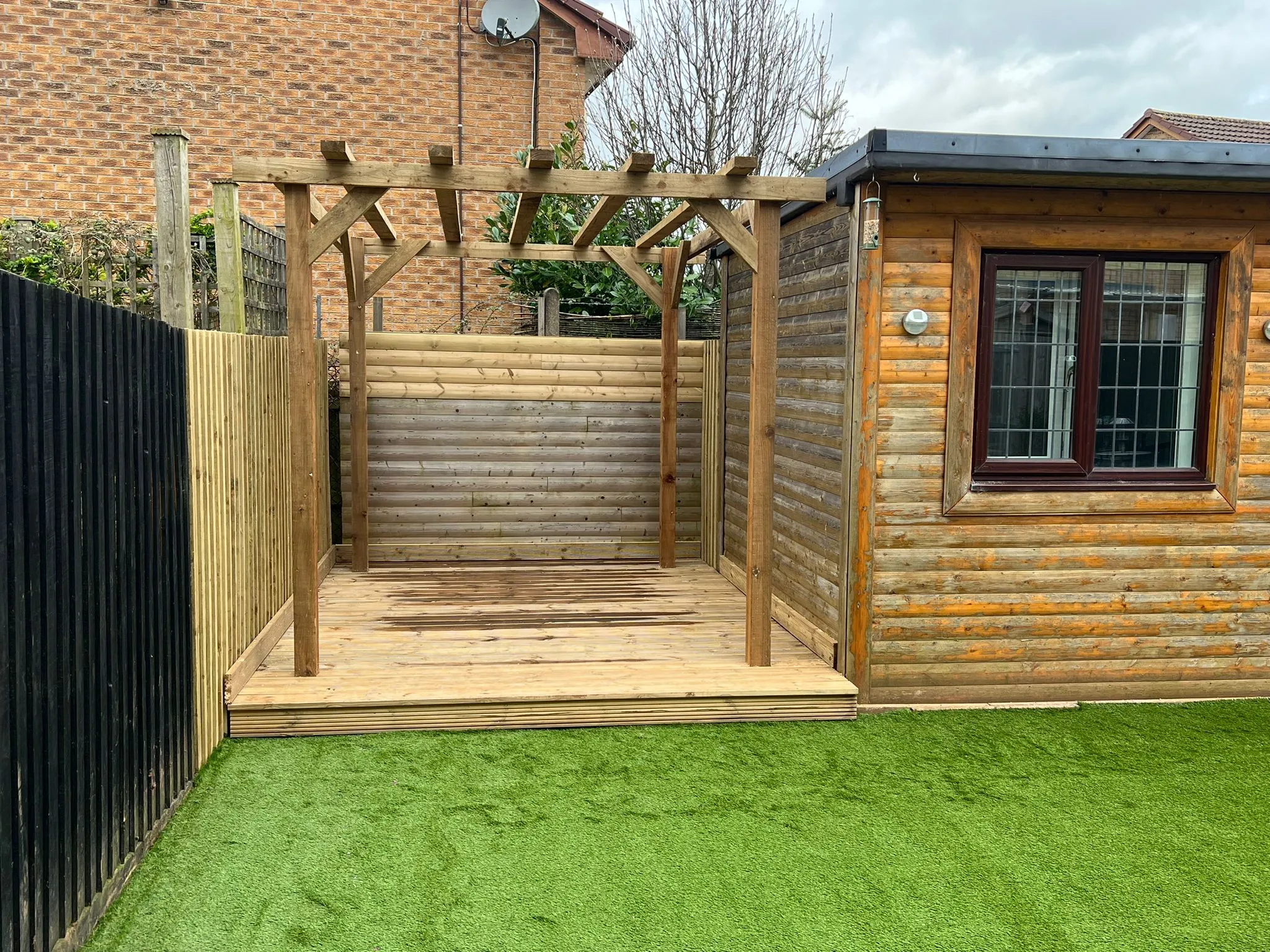 A small wooden shed with a wooden deck.