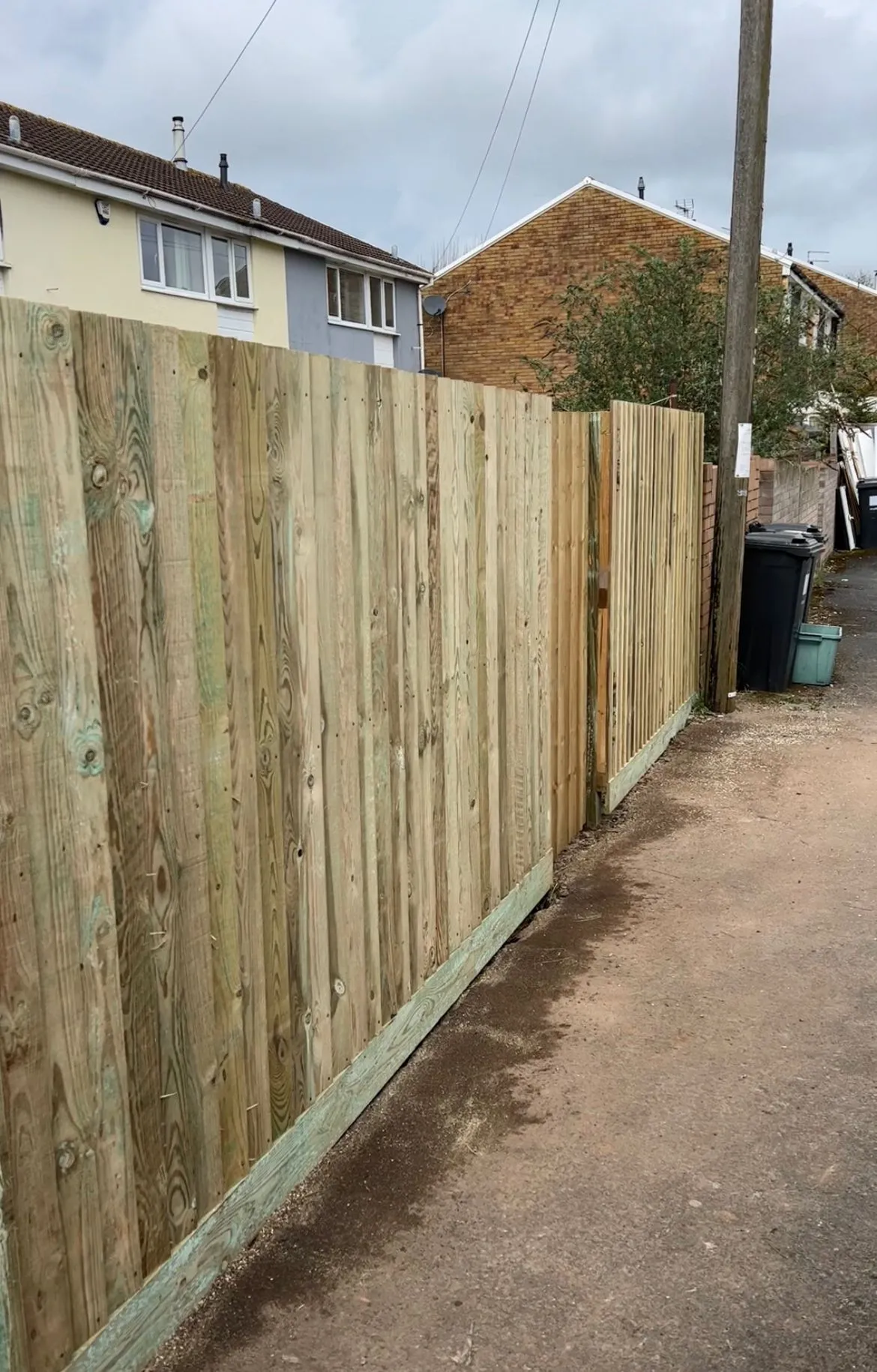 A wooden fence is next to a house.
